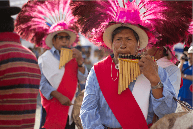 Locals in Chilean dress play a traditional woodwind instrument
