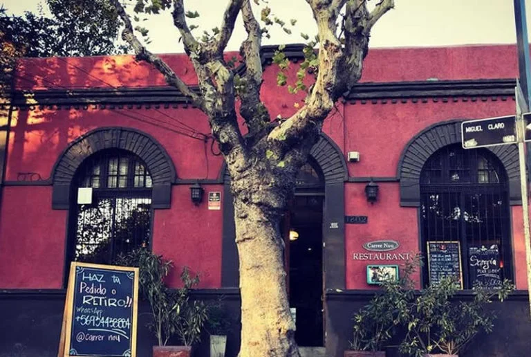 The entranve of Carrer Nou, a traditional building with a large tree