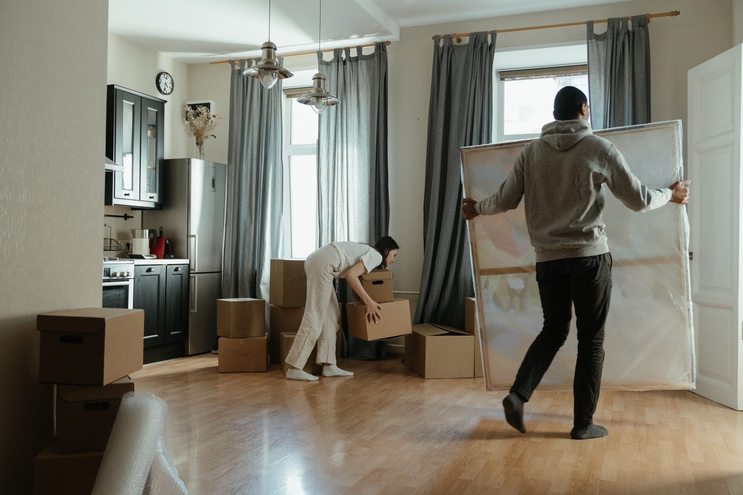 Moving boxes stacked in a bright, empty Providencia apartment with the Andes visible through the window